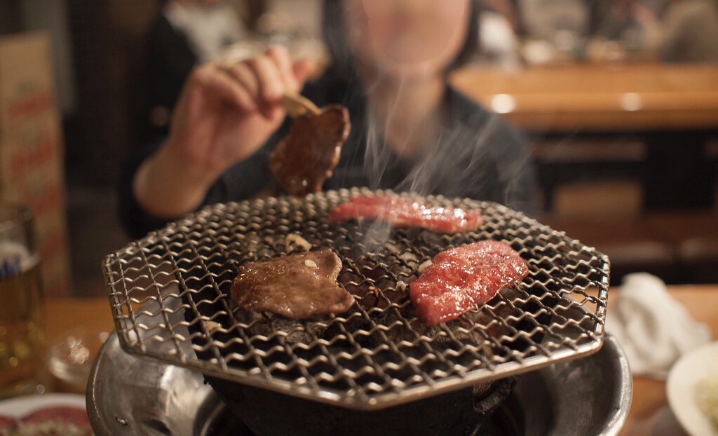 七輪の網の上で焼けるお肉。参考写真